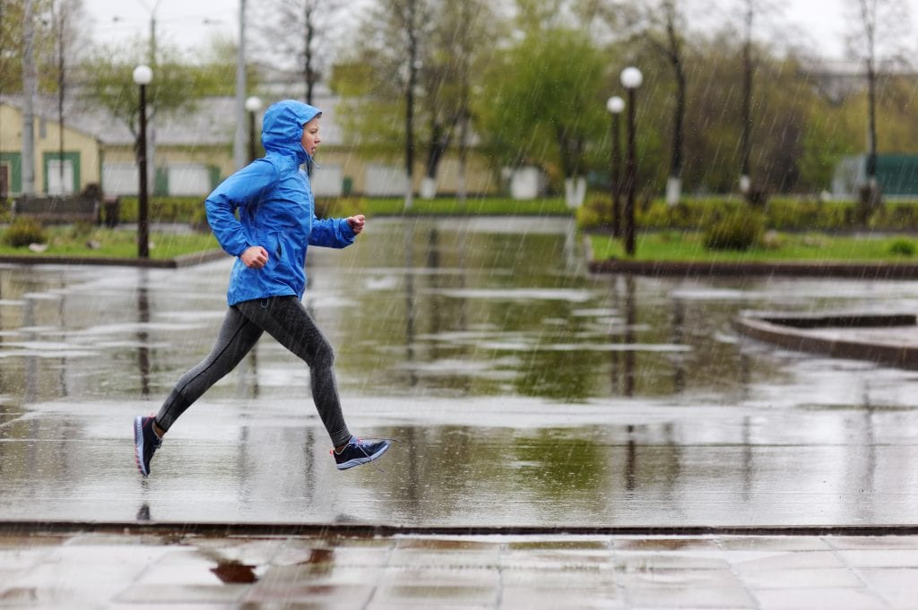 Femme courant sous la pluie.